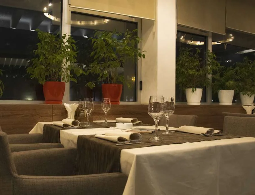 Enterijer restorana Tornik — postavljeni stolovi uz prozore